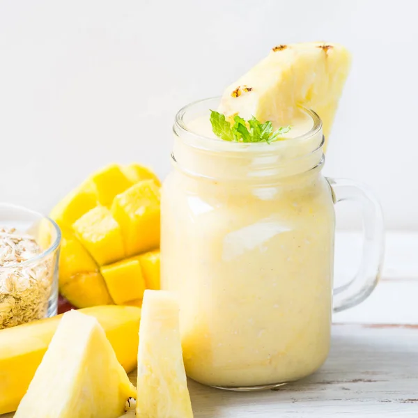 Mango, muz, ananas ve yulaf ezmesi Smoothie kavanozun içinde