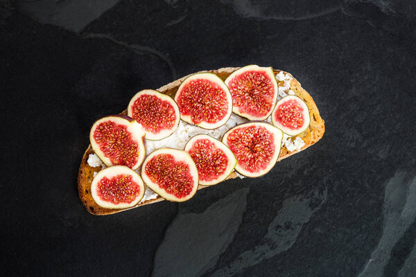 Healthy snack from sourdough bread toasts, figs and ricotta chee