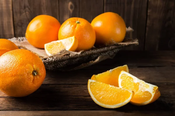 Frische reife Orangen und Orangenscheiben — Stockfoto