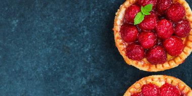 Nane yaprakları ile frambuazlı tart ve krema şeker koyu arka plan üzerinde ile kaplı