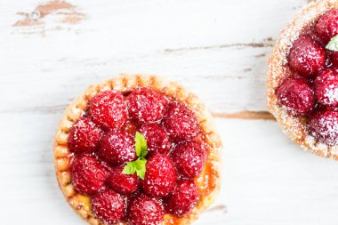 Nane yaprakları ile frambuazlı tart ve beyaz zemin üzerine krema şeker kaplı