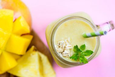 Mango, muz, ananas ve yulaf ezmesi Smoothie kavanozun içinde