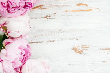 Beyaz ahşap zemin üzerinde pembe peonies taze demet. Kart kavramı, üstten görünüm, kopya alanı metin için