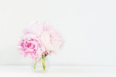 Işık arka plan üzerinde küçük vazo içinde pembe peonies taze demet. Kart kavramı, kopya alanı metin için