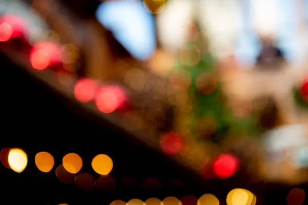 Abstract bokeh made from Christmas lights in the shop on black background — Stock Photo, Image