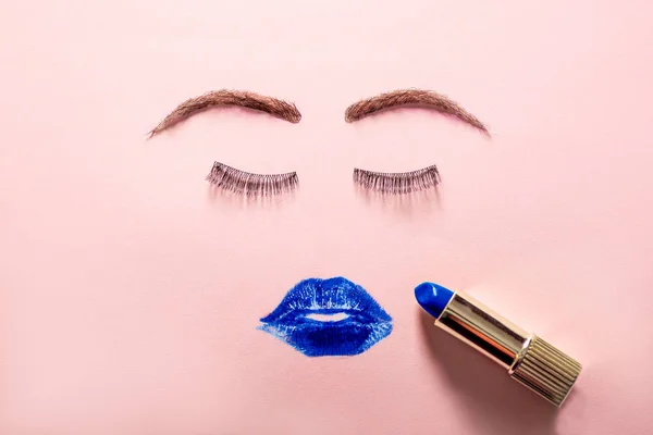 Cara creativa de mujer hecha de pestañas, cejas de peluca y manchas de lápiz labial azul como labios . — Foto de Stock