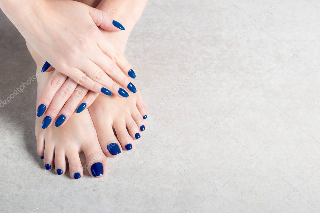 Young lady is showing her blue manicure and pedicure nails