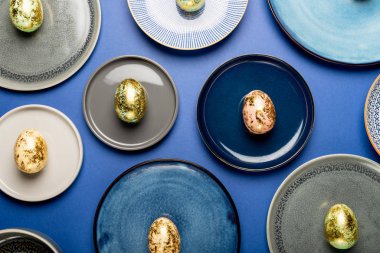 Mavi arkaplanda pastel renkli Paskalya yumurtaları ile farklı tabaklar