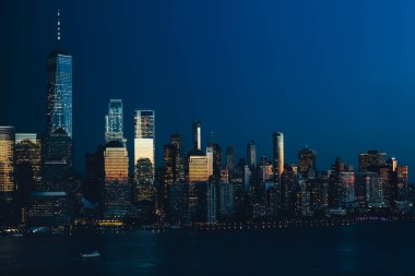 New York City silueti ve Manhattan şehir merkezi gece boyunca Jersey City 'den