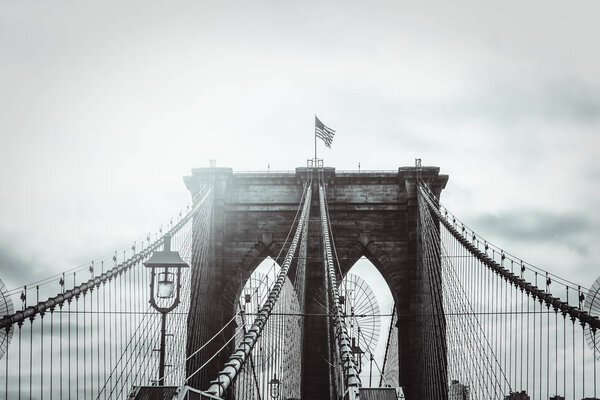 Details of the Brooklyn Bridge in New York City, USA. Toned image with sun light leak, black and white image