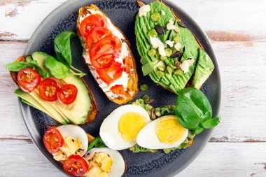 Avokado, yumurta, domates ve susamlı patates kızartması.