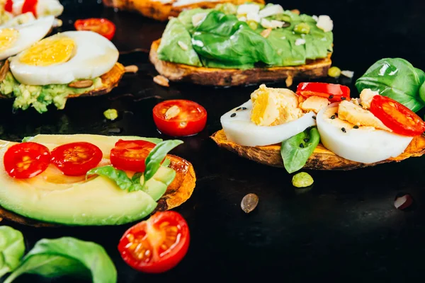 Rostat bröd av sötpotatis med avokado, ägg, tomater och sesamfrön — Stockfoto