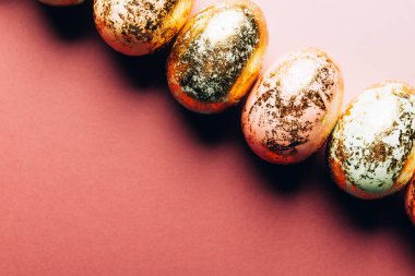 Pembe arka planda doğal benekli pastel renkli Paskalya yumurtaları. Mutlu Paskalya kartı konsepti, minimalist tasarım, kopyalama alanı