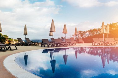 Havuz kenarındaki boş güneşlikler, koronavirüs, Avrupa