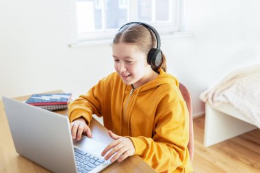 Okul çağındaki kız evde eğitim görüyor.