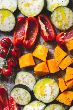 Patlıcan, kırmızı biber, vişneli domates, tereyağlı kabak gibi farklı sebzelerden sağlıklı Detoks Yemeği. Kızartma için hazırlanmış çiğ sebze dilimleri, basit aile yemeği.