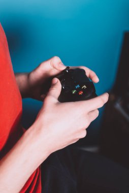 Genç adam oyun konsolunda oyun alanıyla oynuyor. Kendini soyutlama, oyun bağımlılığı. Evde kal.