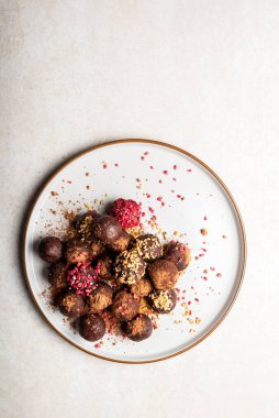 Badem ve Kakao, Kara Çikolata ve Gri Tabakta Fındık Ezmesi ve Işık Arkaplan gibi çeşitli ev yapımı çiğ vejetaryen mantarları veya Enerji Topları