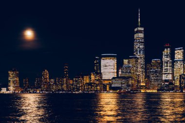 New York şehrinin gökdeleni ve Manhattan şehir merkezinin gece boyunca Jersey City ve dolunay manzarası inanılmaz.