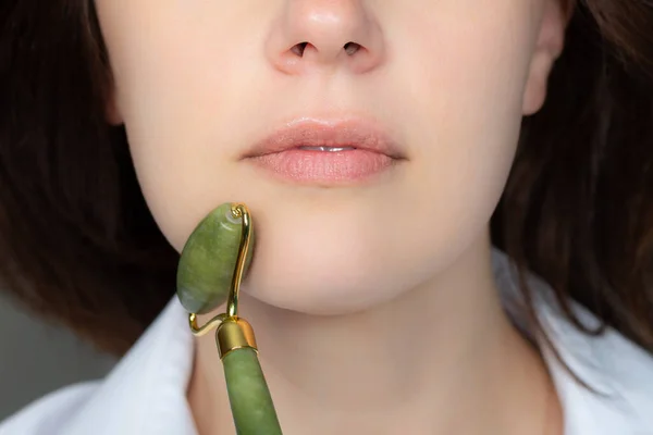 Woman with jade face roller — Stock Photo, Image