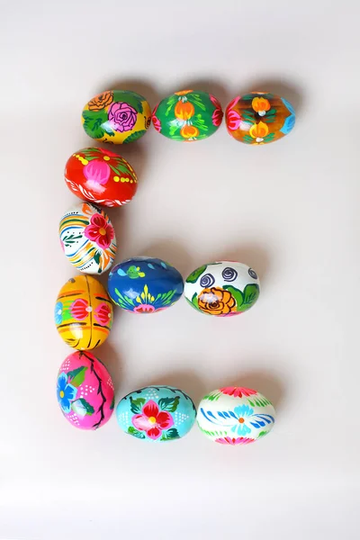 Een van de letters van het woord "Pasen". Letters zijn gemaakt van paaseieren, van verschillende kleuren en met verschillende patronen — Stockfoto