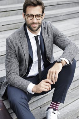 Yakışıklı işadamı merdiven üzerinde oturan