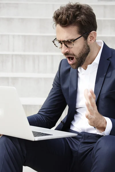 Shocked businessman using laptop — Stock Photo, Image