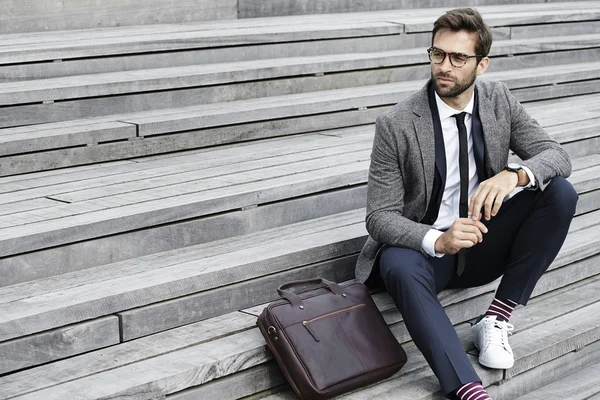 Hombre de negocios guapo sentado en la escalera — Foto de Stock