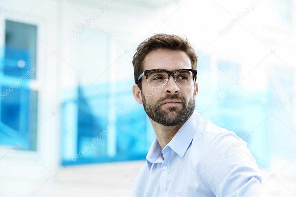 Serous man with stubble and glasses