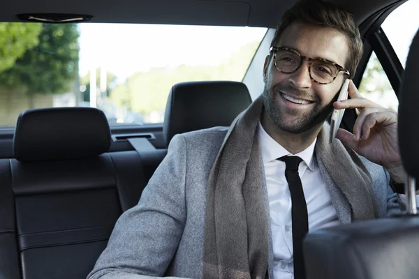 Empresário no carro tomando chamada no smartphone — Fotografia de Stock