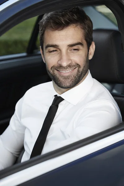 Homme d'affaires souriant conduisant une voiture — Photo