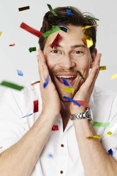 Homem feliz com confete colorido — Fotografia de Stock