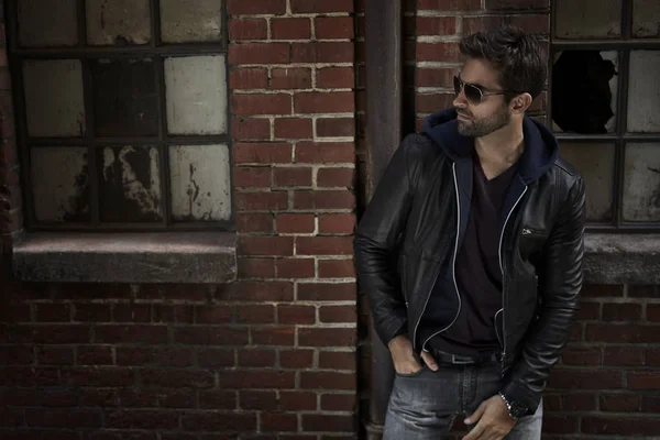 Ceketli ve kot pantolonlu adam.