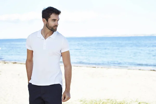 Yakışıklı bir adam sahilde duran — Stok fotoğraf