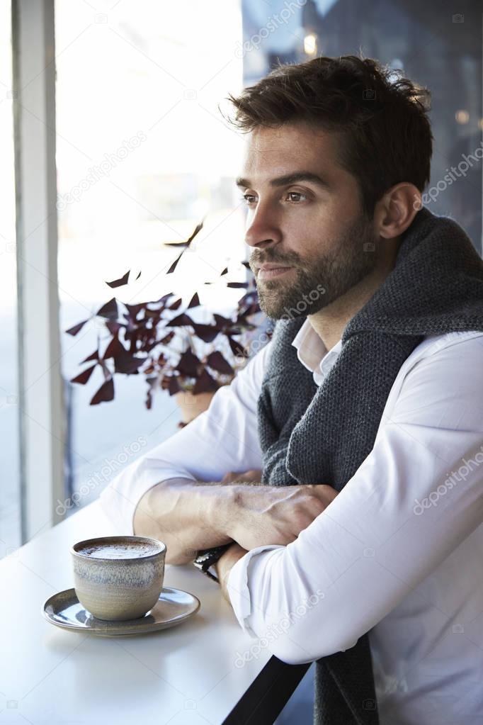 Thoughtful man with coffee in cafe