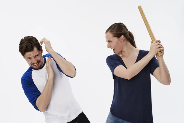 Woman threatening man with stick — Stock Photo, Image