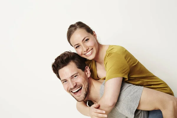 Laughing couple piggybacking — Stock Photo, Image