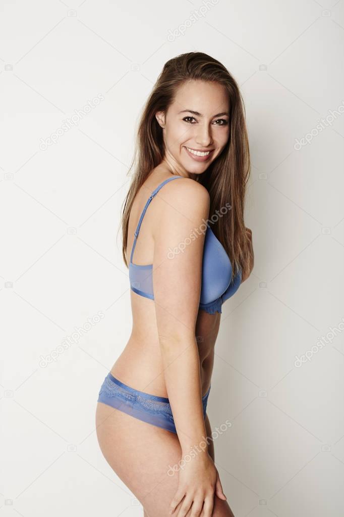 Foto de Brunette babe in blue lingerie, smiling do Stock
