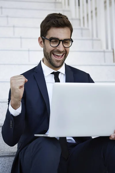 Celebrating businessman using laptop — Stock Photo, Image