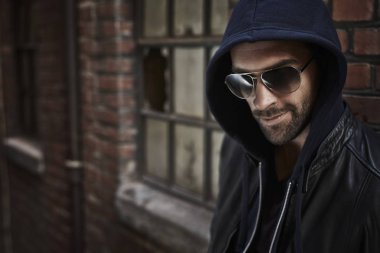 Güneş gözlüğü ve hood yakışıklı adam