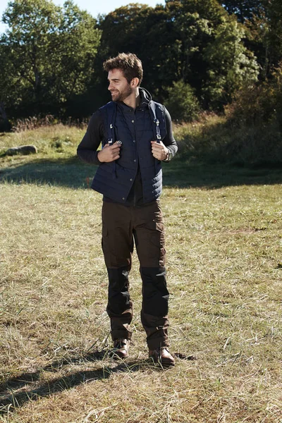 Hiking man standing in field
