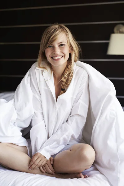 Женщина в пижаме сидит в постели — стоковое фото