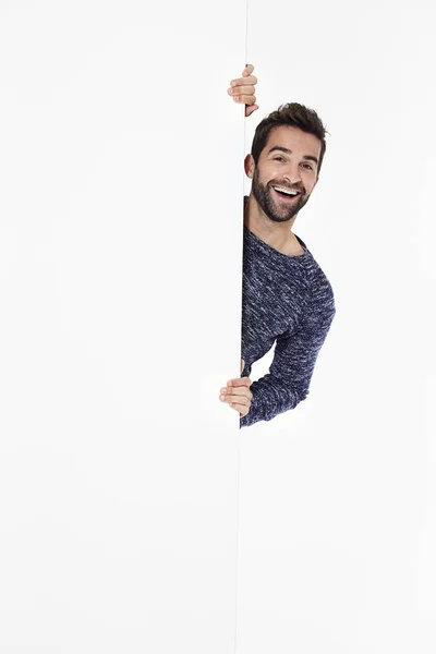 Man laughing behind white wall — Stock Photo, Image