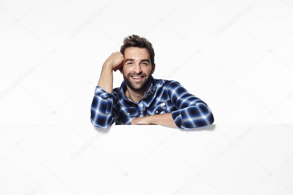 Man leaning on white surface