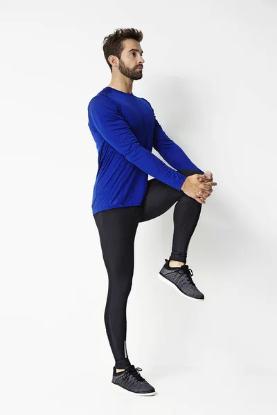 Uomo in abbigliamento sportivo stretching — Foto Stock