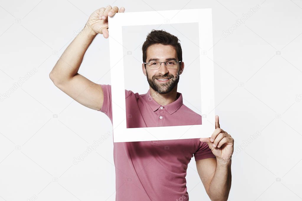 Smiling man holding frame