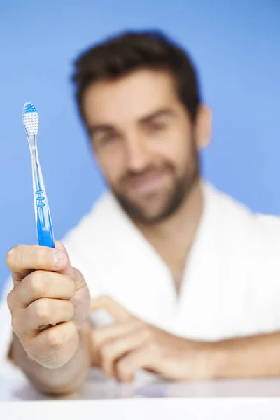 Homme tenant une brosse à dents — Photo