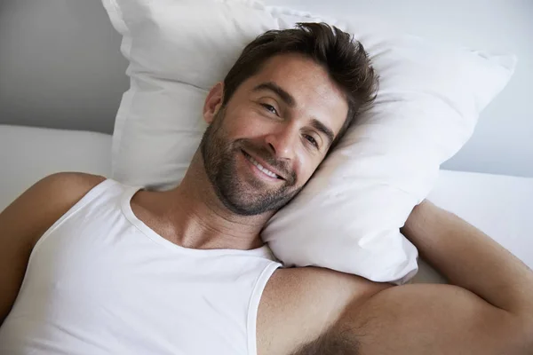 Hombre sonriente en la cama — Foto de Stock