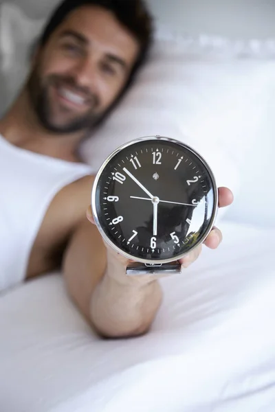 Homem segurando despertador — Fotografia de Stock