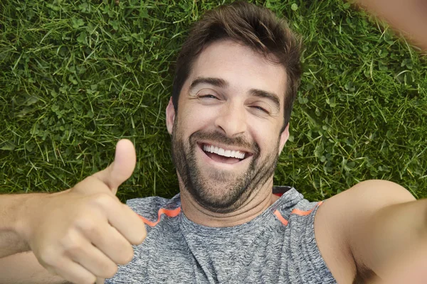 Man showing thumb up on grass — Stock Photo, Image